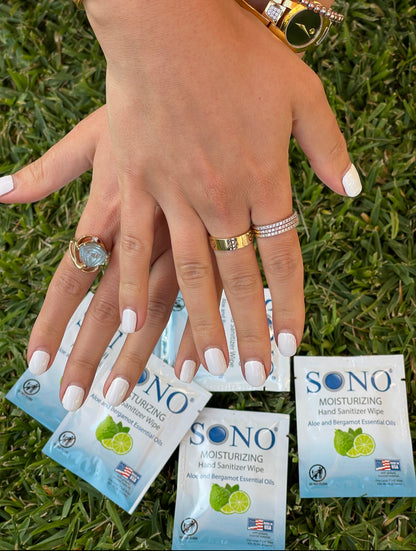 Hand holding SONO hand wipes wipes on grass